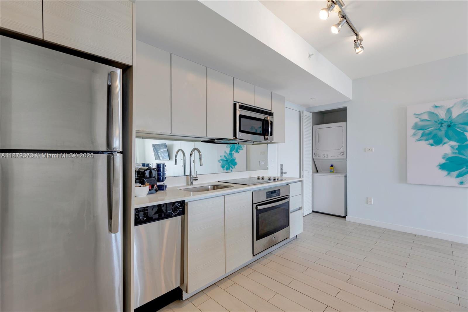 2602 East Hallandale Beach Boulevard, Unit R2109 Hallandale Beach, FL 33009 - Photo 13 of 47 a kitchen with a sink a refrigerator and a stove top oven