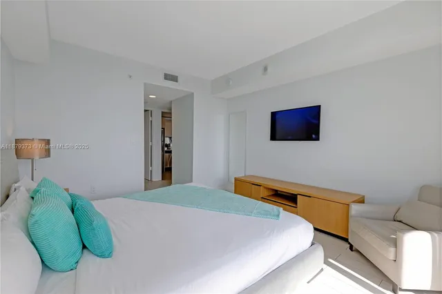 a bedroom with a bed and a television