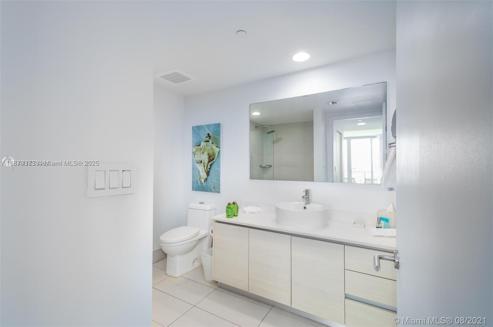 2602 East Hallandale Beach Boulevard, Unit R2109 Hallandale Beach, FL 33009 - Photo 15 of 47 a spacious bathroom with a double vanity sink toilet and a mirror
