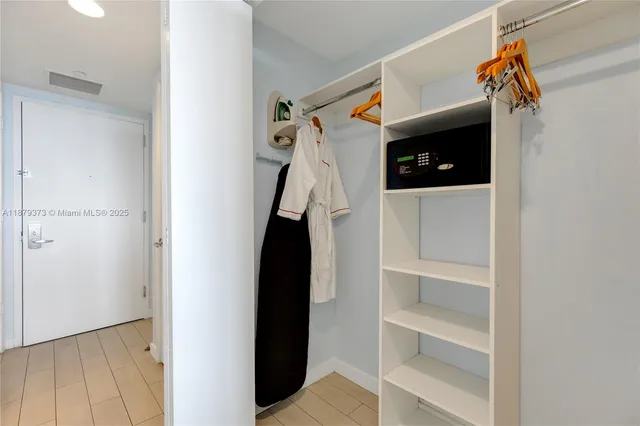 a view of walk in closet with clothes and shoes