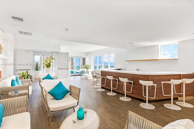 a living room with large windows and a table