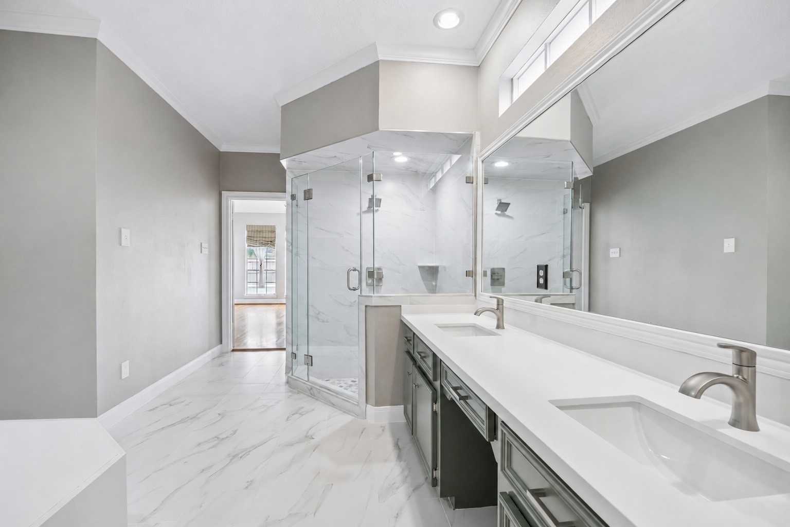 7915 Huddersfield Court Spring, TX 77379 - Photo 23 of 37 Alternate view of the updated primary bath highlighting the dual sinks, generous vanity space, glass-enclosed shower, and polished tile flooring.