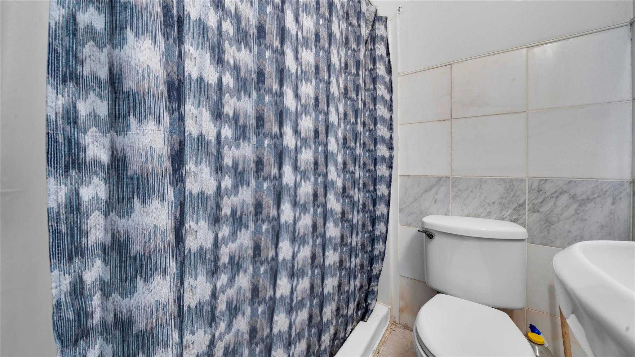 820 Northwest 23rd Street Miami, FL 33127 - Photo 32 of 64 a white toilet sitting next to a shower curtain