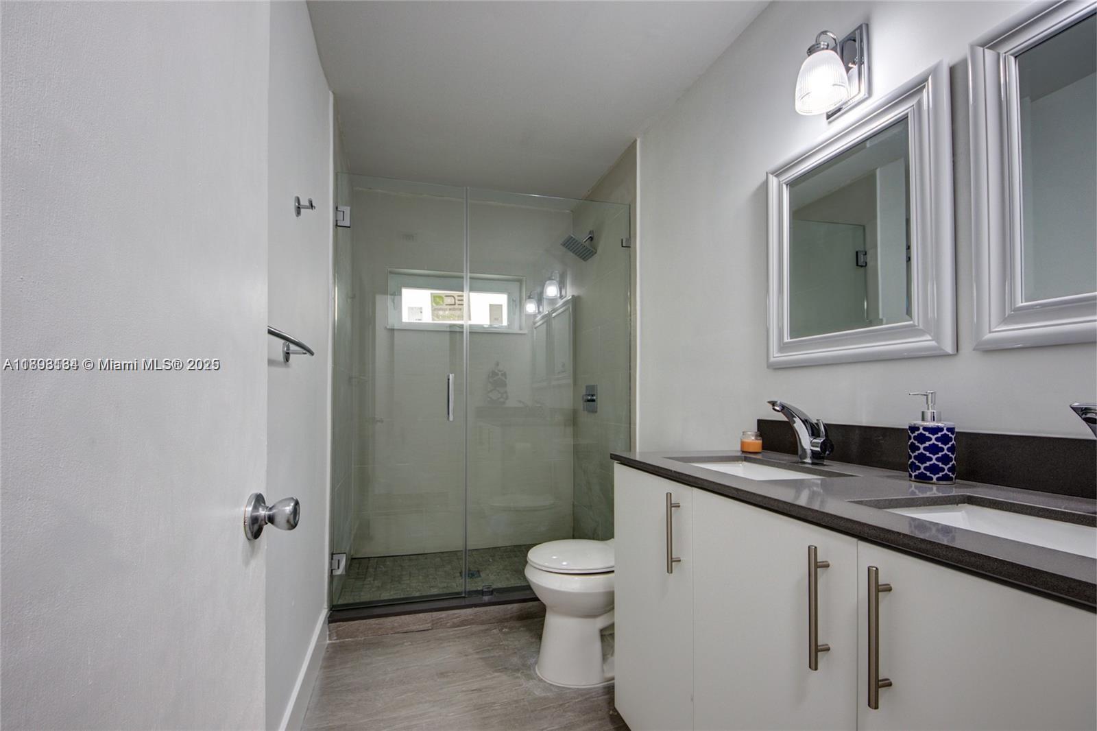 2363 Southwest 21st Terrace Miami, FL 33145 - Photo 11 of 19 a bathroom with a granite countertop sink toilet a mirror a vanity and shower