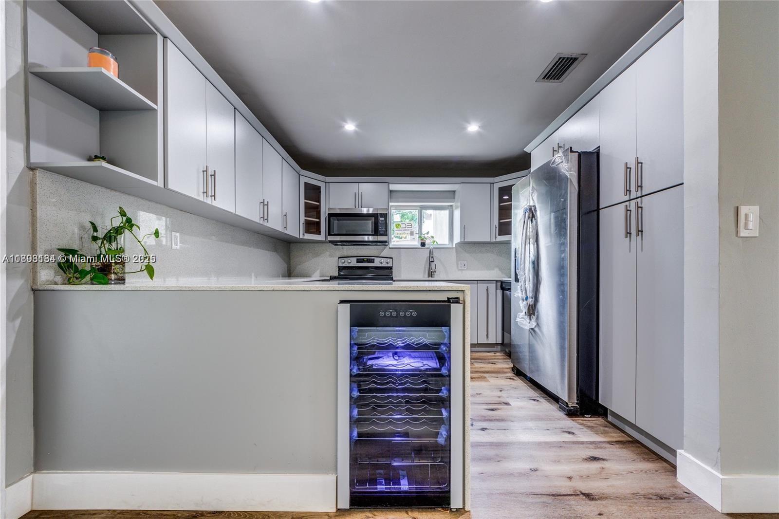 2363 Southwest 21st Terrace Miami, FL 33145 - Photo 3 of 19 a kitchen with stainless steel appliances a refrigerator sink and cabinets