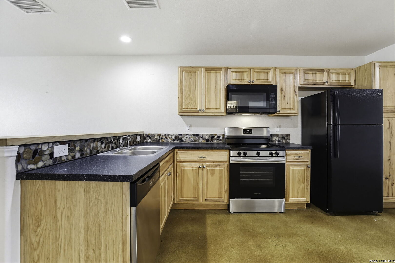 752 Cimarron, Unit B Spring Branch, TX 78070 - Photo 5 of 23 a kitchen with stainless steel appliances granite countertop a stove a refrigerator and a sink
