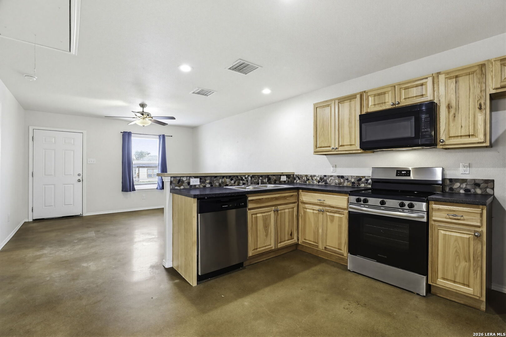 752 Cimarron, Unit B Spring Branch, TX 78070 - Photo 6 of 23 a kitchen with granite countertop a stove top oven and sink