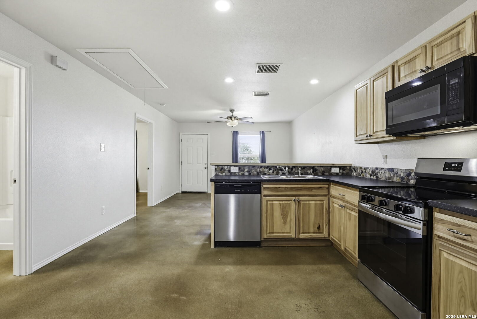 752 Cimarron, Unit B Spring Branch, TX 78070 - Photo 7 of 23 a kitchen with stainless steel appliances granite countertop a stove a sink and a microwave