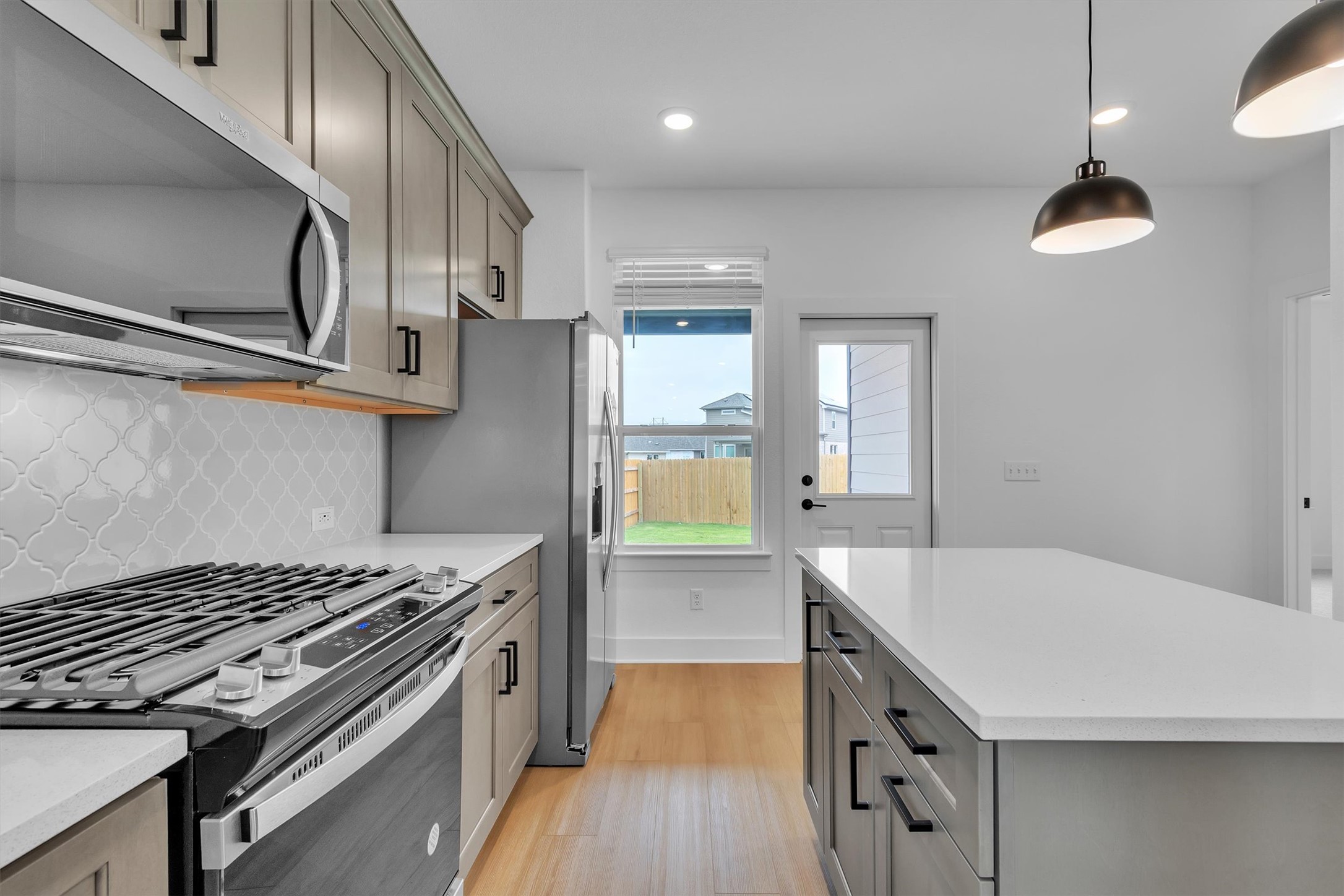 368 Bridge Deck Loop Kyle, TX 78640 - Photo 23 of 40 Kitchen featuring stainless steel appliances, gray cabinets, light wood-type flooring, tasteful backsplash, and recessed lighting