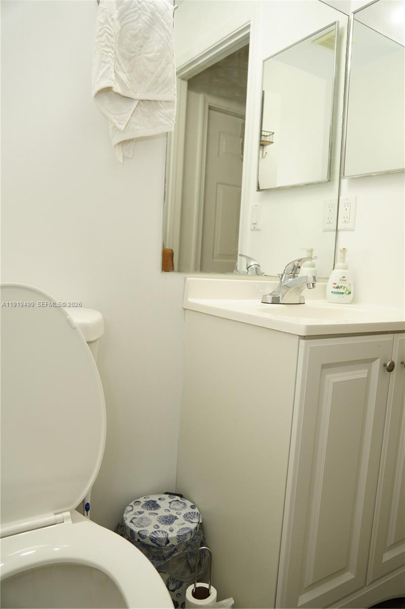 159 Hidden Ct Road Hollywood, FL 33023 - Photo 11 of 29 a bathroom with a sink a toilet and a mirror