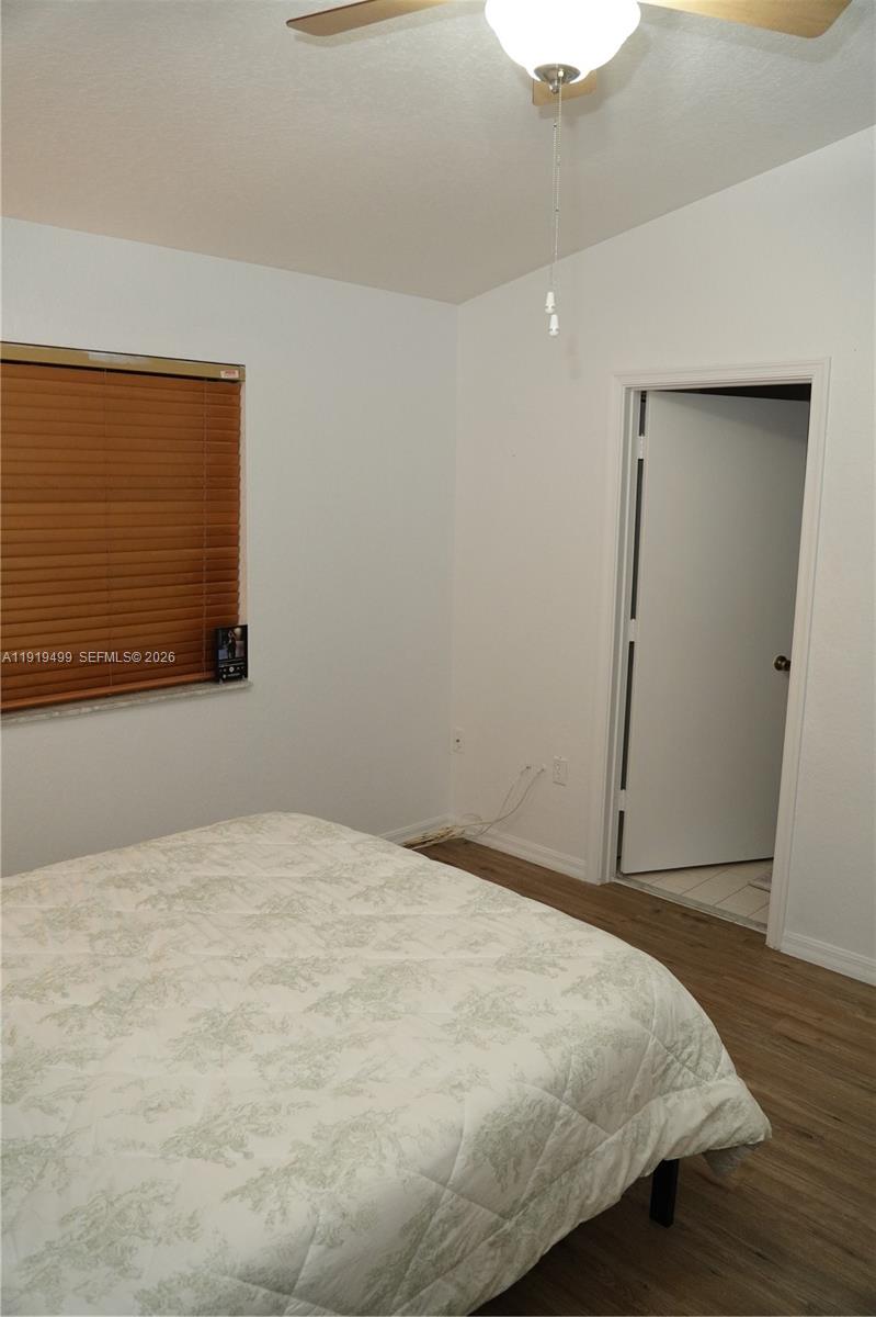 159 Hidden Ct Road Hollywood, FL 33023 - Photo 16 of 29 a bedroom with a bed and wooden floor