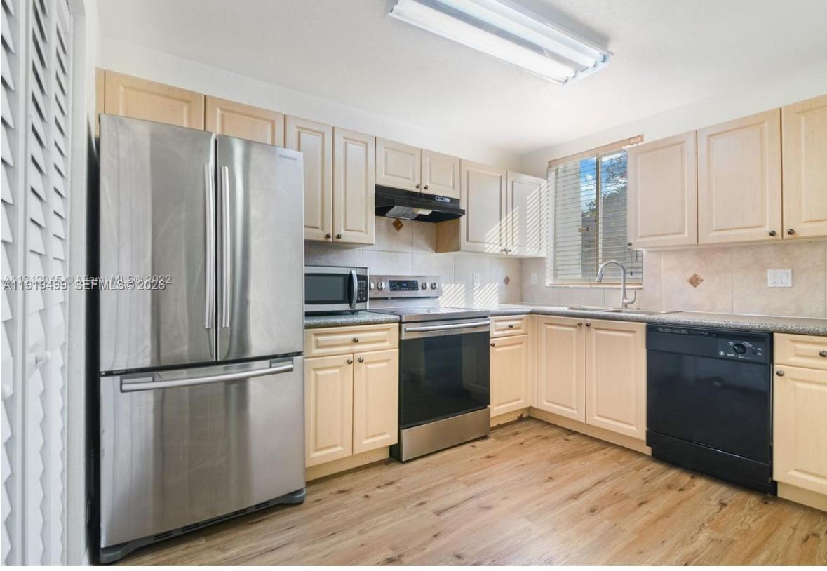 159 Hidden Ct Road Hollywood, FL 33023 - Photo 3 of 29 a kitchen with granite countertop stainless steel appliances a refrigerator a sink a stove a microwave and cabinets