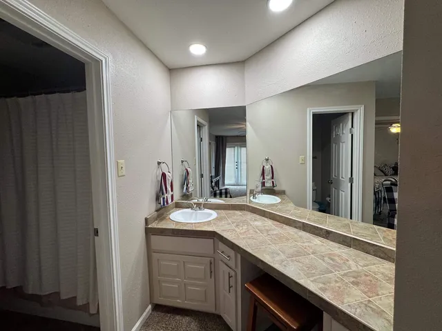 a bathroom with a granite countertop sink and a mirror
