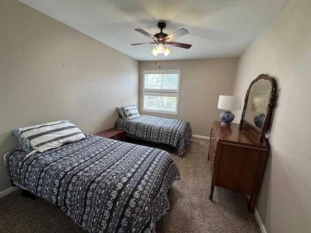 a bedroom with two beds and a chandelier