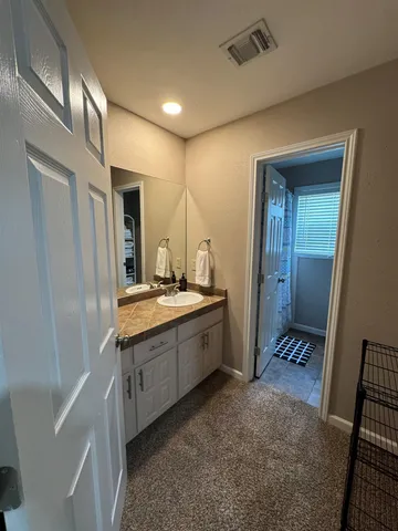 a large bathroom with a granite countertop sink and a mirror