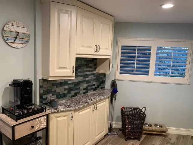 a kitchen with stainless steel appliances granite countertop a table chairs and a refrigerator