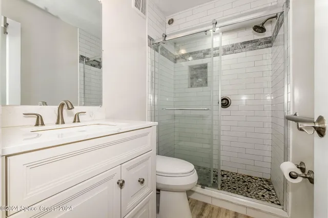 a bathroom with a sink a toilet and shower