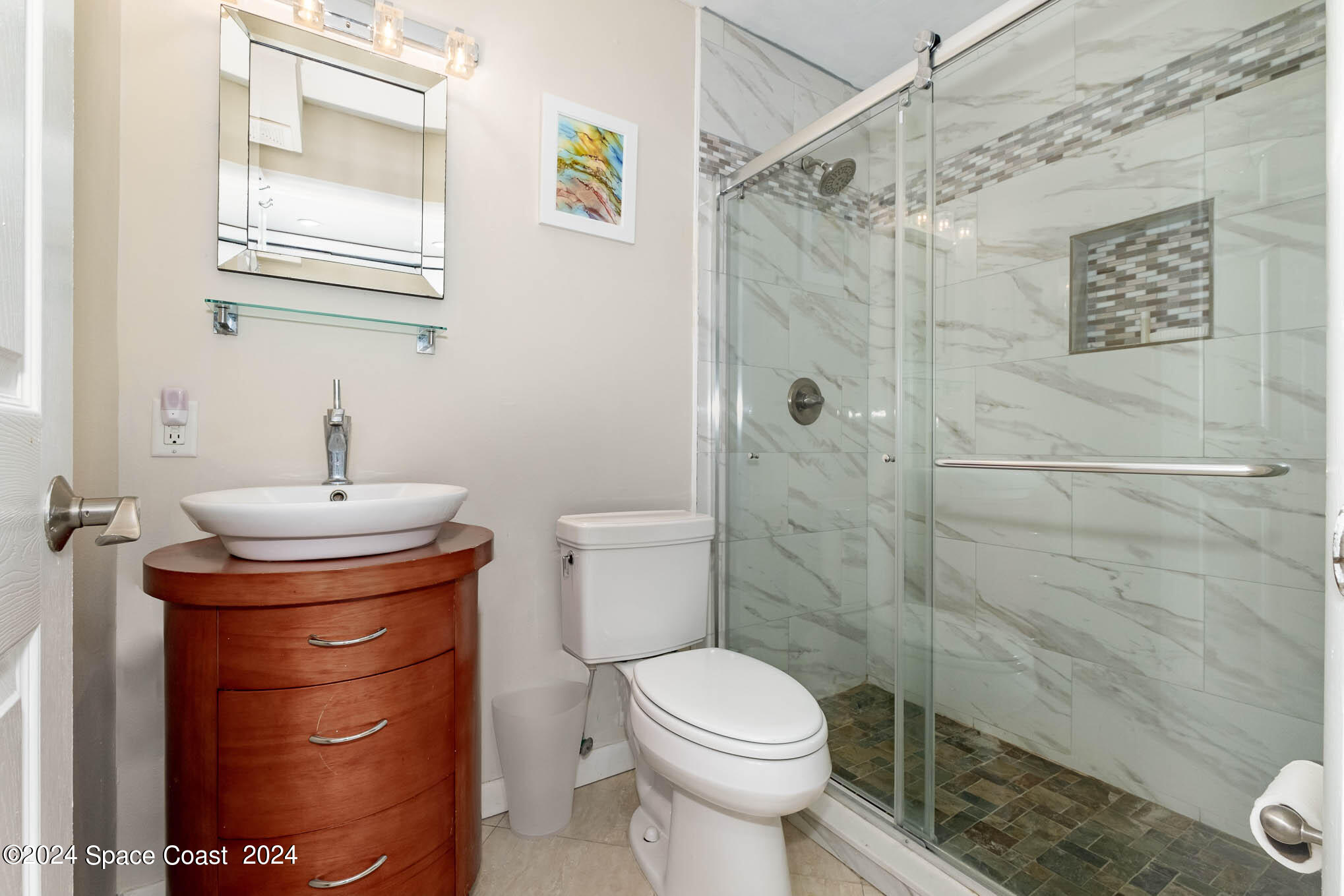 4800 Ocean Beach Boulevard, Unit 311 Cocoa Beach, FL 32931 - Photo 18 of 22 a bathroom with a sink a toilet and shower