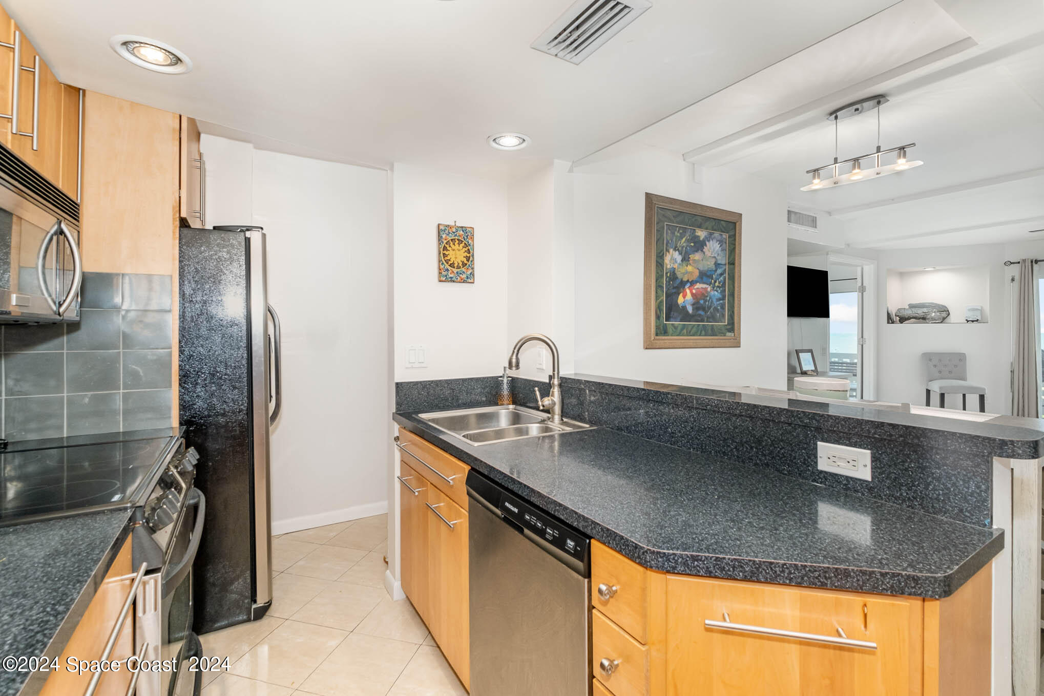 4800 Ocean Beach Boulevard, Unit 311 Cocoa Beach, FL 32931 - Photo 6 of 22 a kitchen with stainless steel appliances granite countertop a sink refrigerator and cabinets