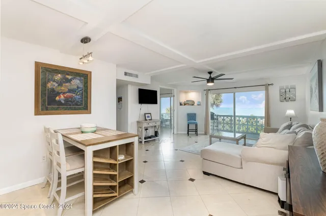 a living room with furniture a large window and kitchen view