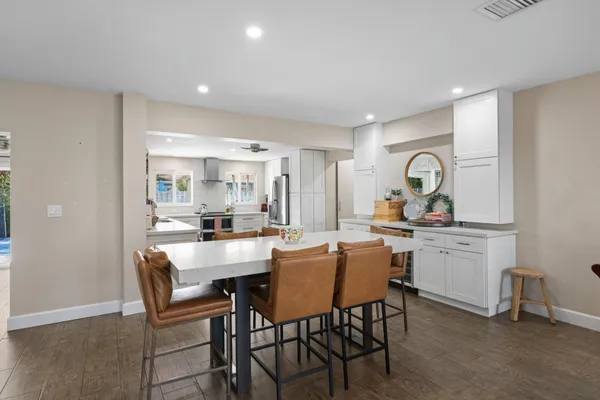 a kitchen with a dining table chairs and white cabinets