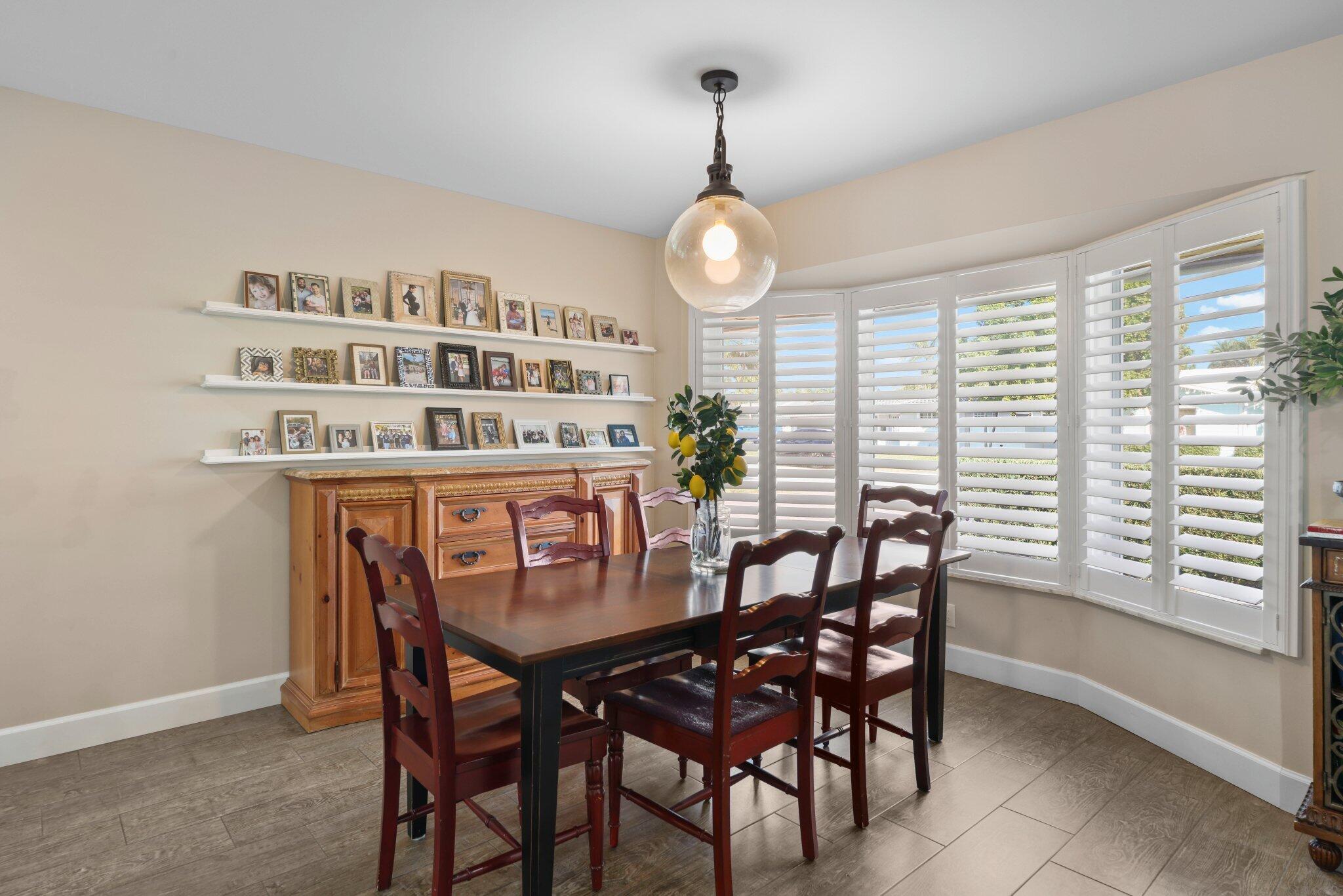4141 Northeast 22nd Terrace Lighthouse Point, FL 33064 - Photo 13 of 46 a view of a dining room with furniture window and wooden floor