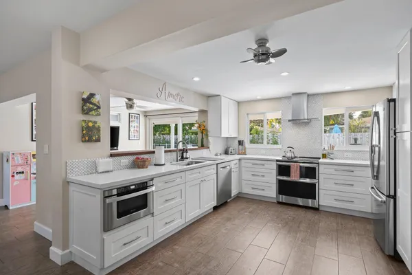 a kitchen with granite countertop cabinets and white stainless steel appliances