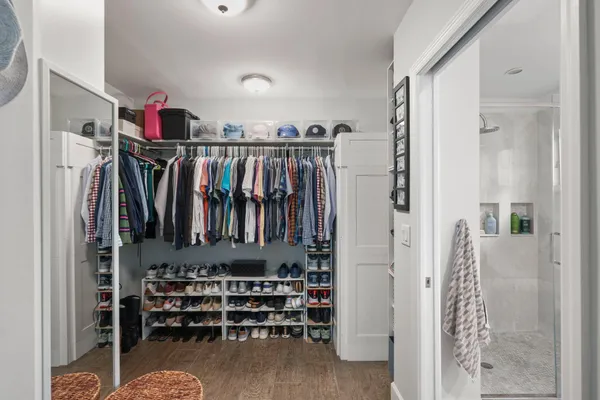 a view of walk in closet with clothes and shoes