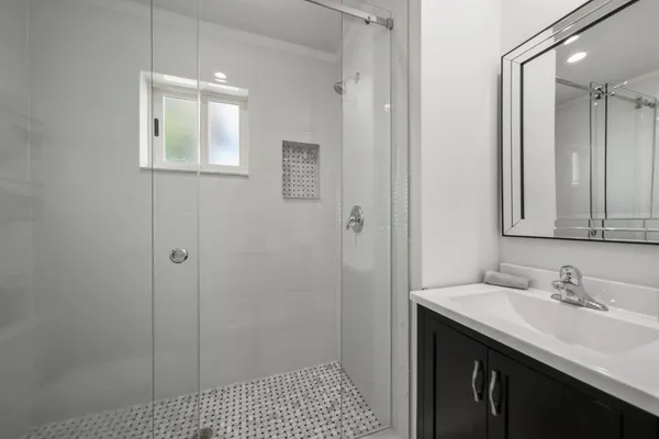 a bathroom with a sink a toilet and shower