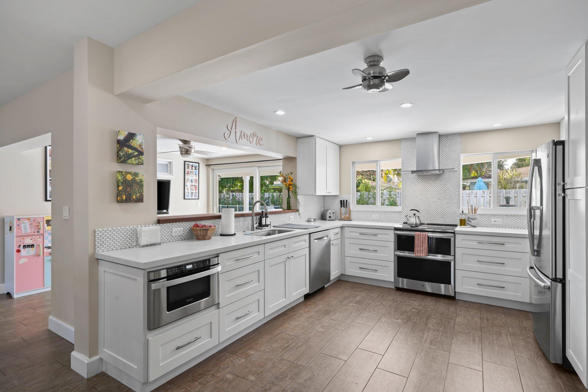 4141 Northeast 22nd Terrace Lighthouse Point, FL 33064 - Photo 6 of 46 a kitchen with granite countertop cabinets and white stainless steel appliances