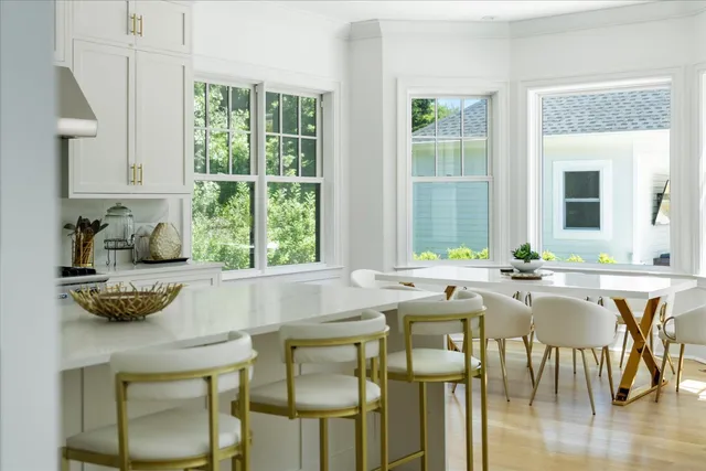 a dining table chairs next to a window