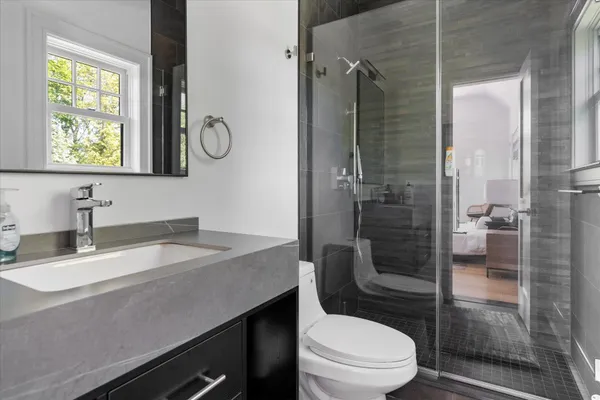 a bathroom with a granite countertop toilet sink and shower