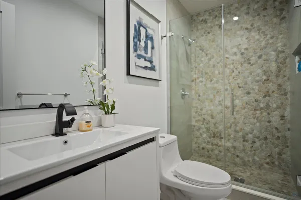a bathroom with a sink a toilet and shower