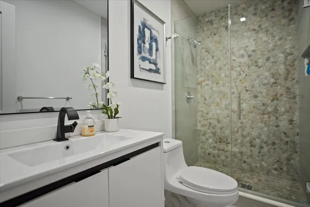a bathroom with a sink a toilet and shower
