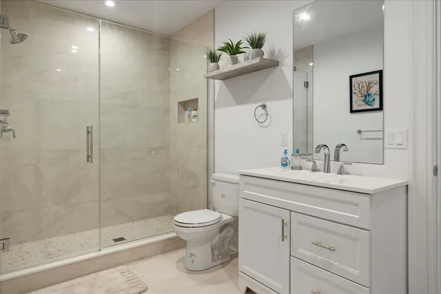 a bathroom with a sink a toilet and shower