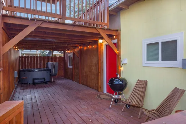 a balcony with wooden floor and yard in the back