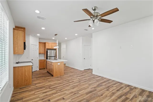 a view of a workspace with wooden floor and a ceiling fan
