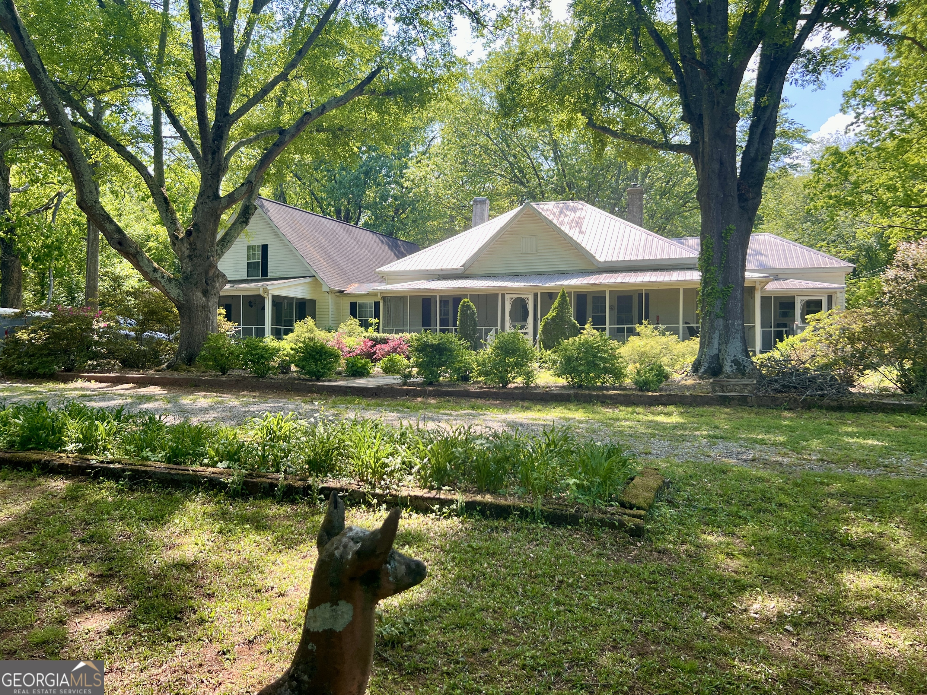 a front view of a house with a yard and large trees