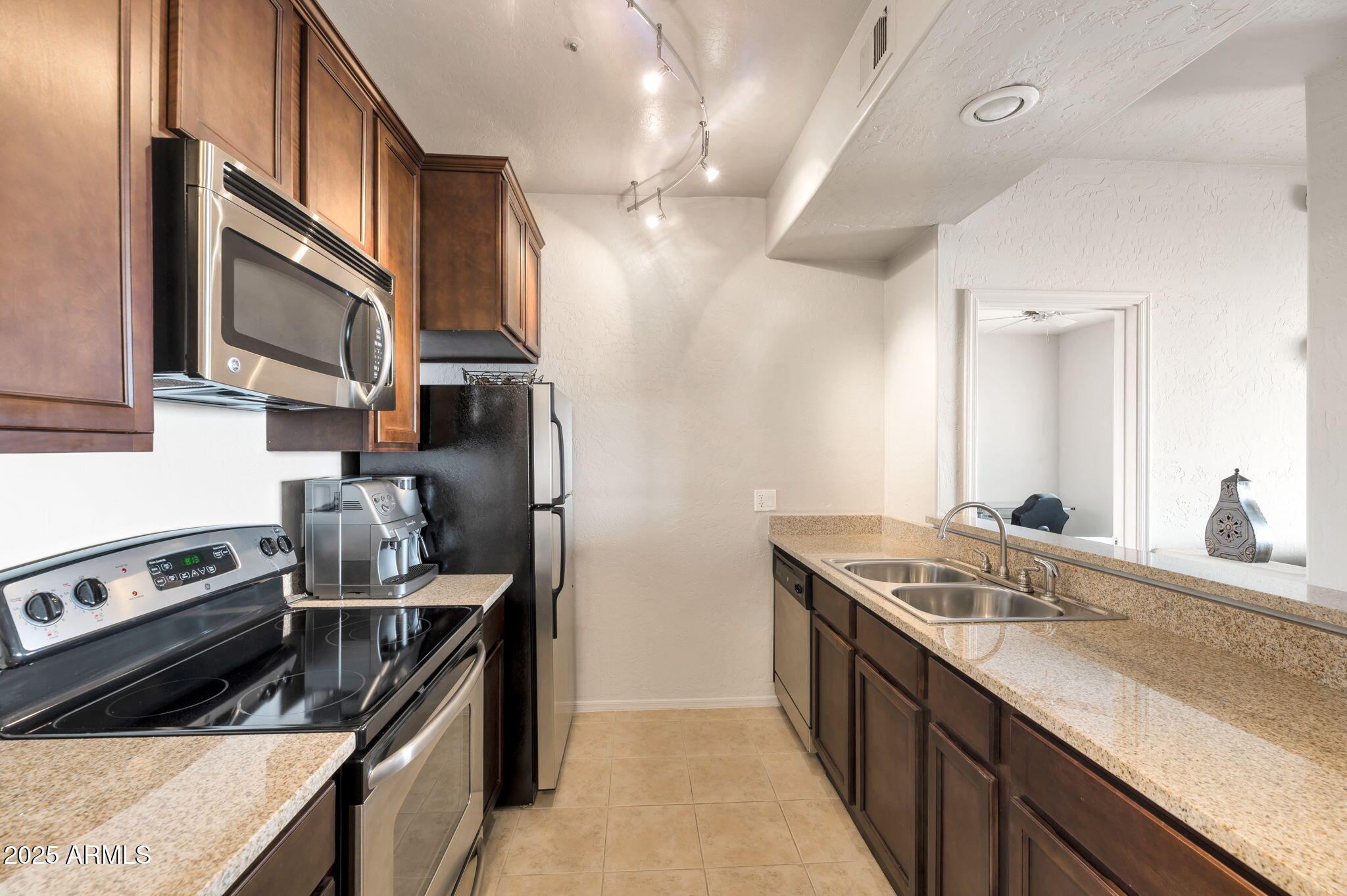a kitchen with stainless steel appliances granite countertop a sink stove and refrigerator