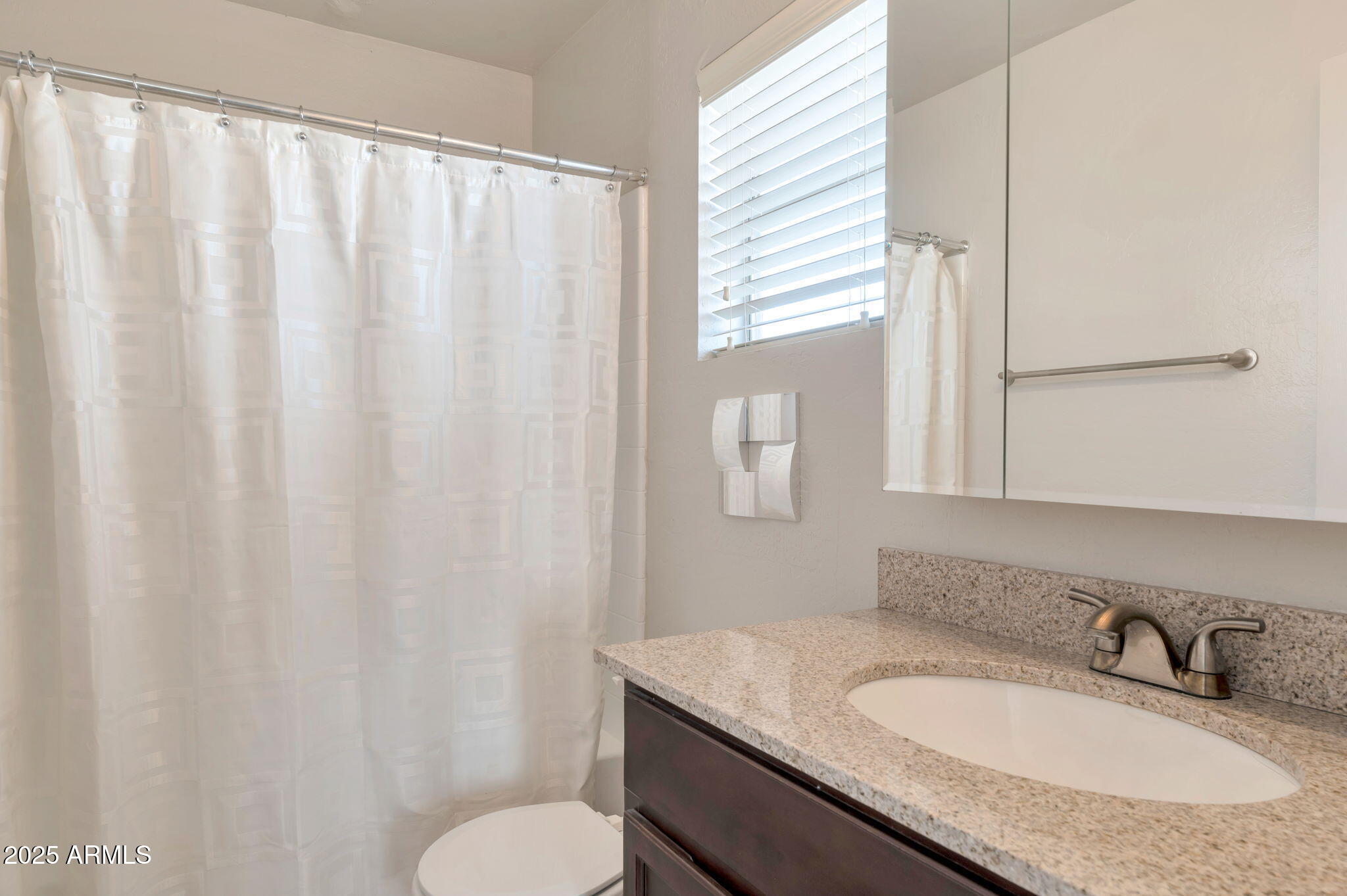 14145 North 92nd Street, Unit 1051 Scottsdale, AZ 85260 - Photo 10 of 21 a bathroom with a granite countertop sink and a mirror