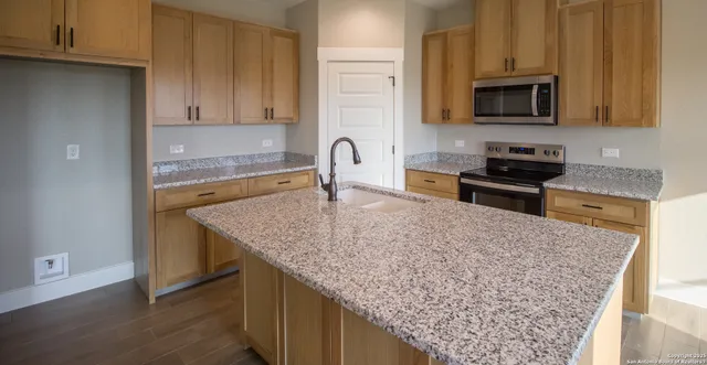 a kitchen with stainless steel appliances granite countertop a stove sink and cabinets