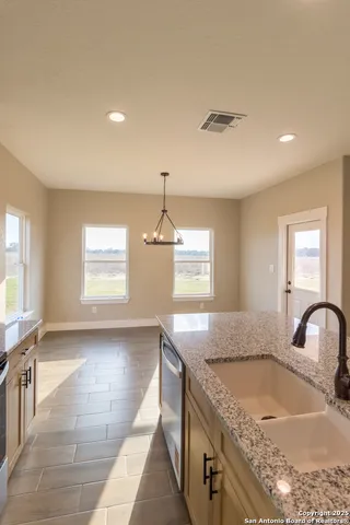 a kitchen with granite countertop a sink and a stove