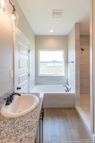 a bathroom with a tub sink and mirror