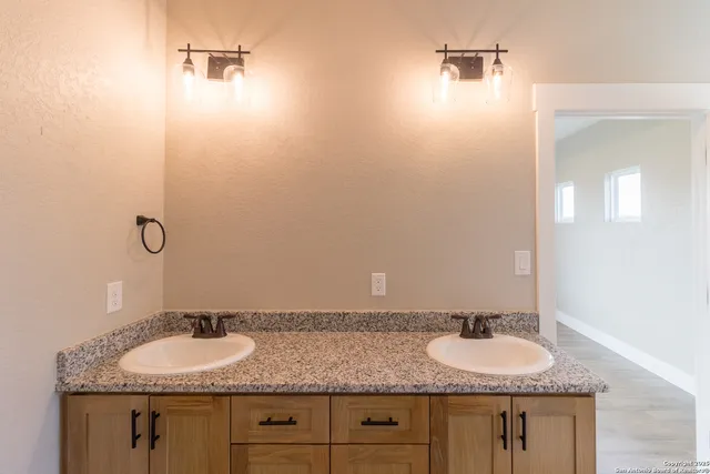a bathroom with a granite countertop sink and a mirror