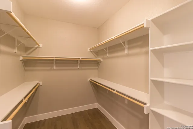 a view of walk in closet with empty racks