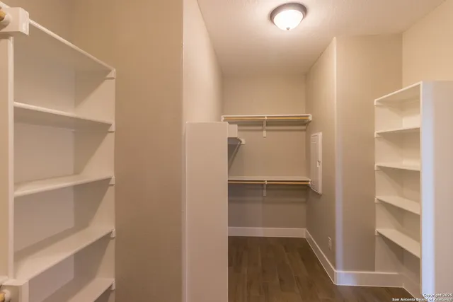 a view of walk in closet with empty racks