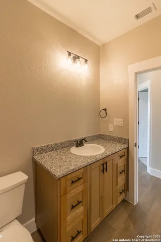 a bathroom with a granite countertop sink and a mirror