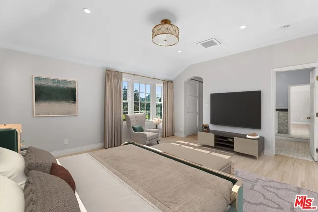 a bedroom with a bed and a flat screen tv