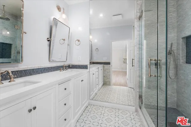 a spacious bathroom with a double vanity sink mirror and shower