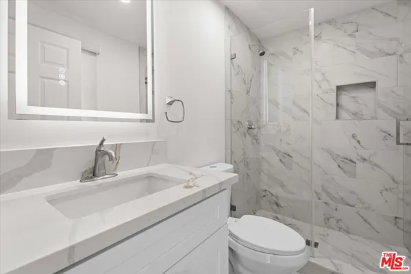 a bathroom with a sink toilet vanity and shower